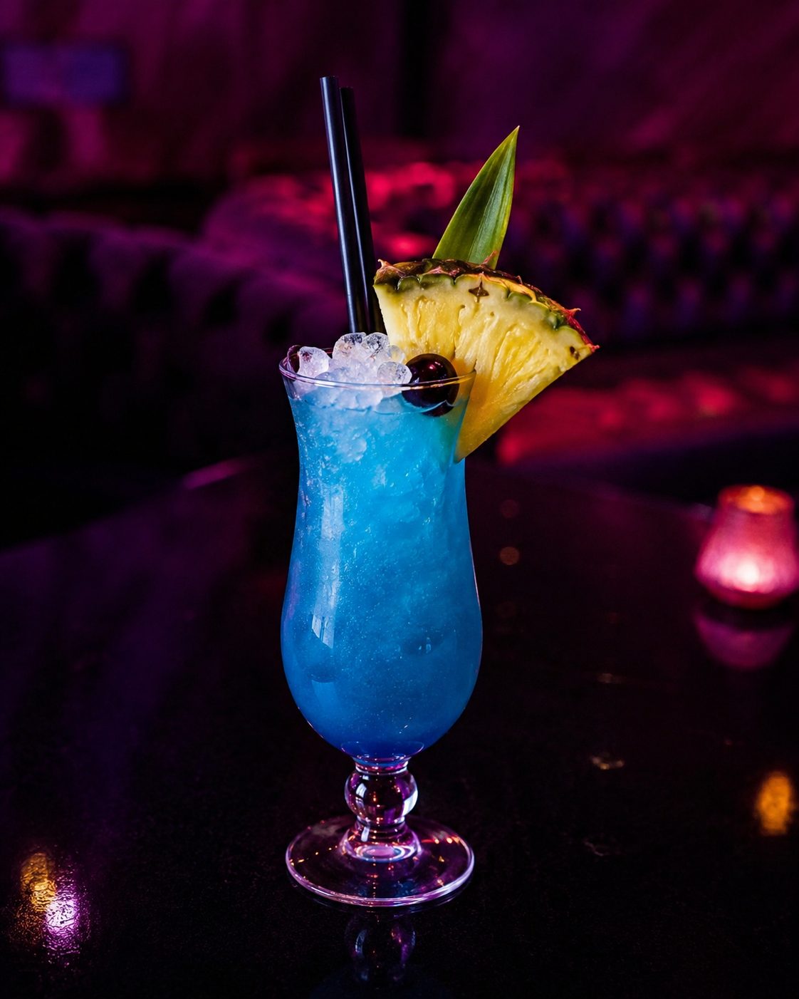 Blauer Cocktail auf Crushed Ice mit Ananasscheibe und Beere.